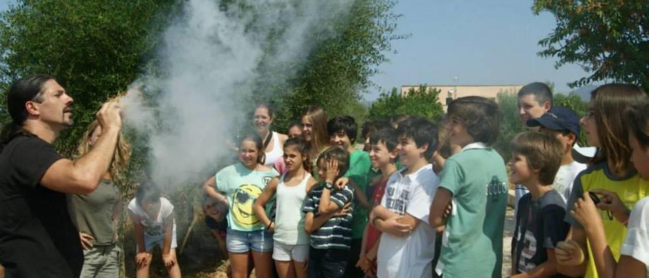 Raúl Prieto enseña cómo hacer fuego a un grupo de jóvenes aventureros.