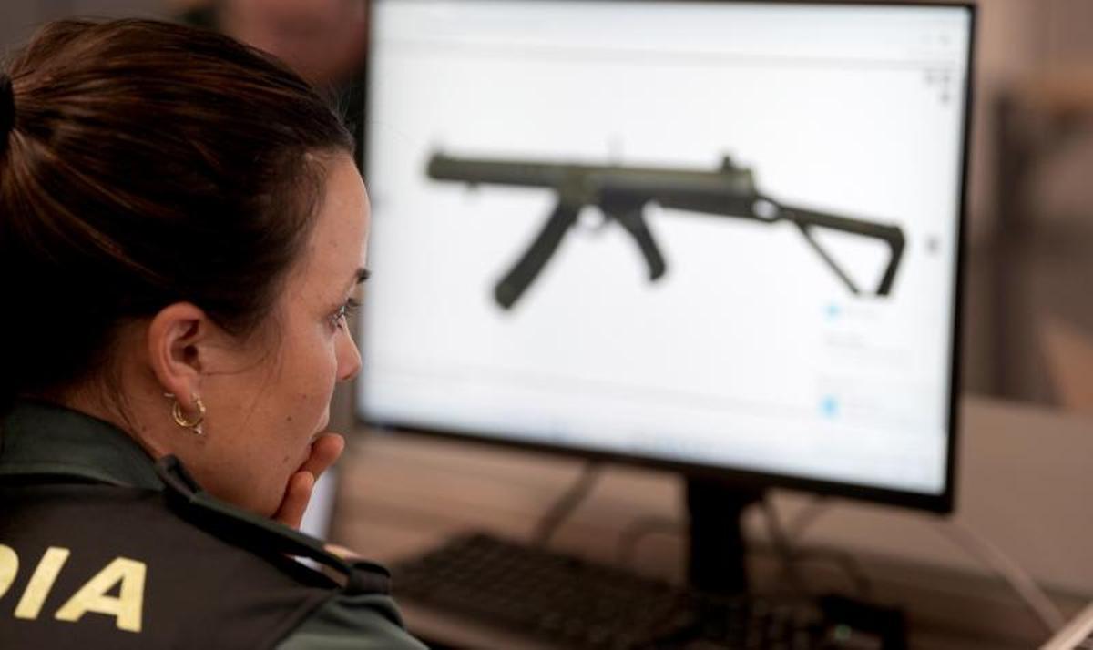 Una agente compara las características de un arma cuya posesión ilegal se investiga en la CiberComandancia