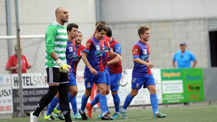 Los jugadores del Langreo felicitan a Luis Nuño por uno de sus tantos al Lugones.