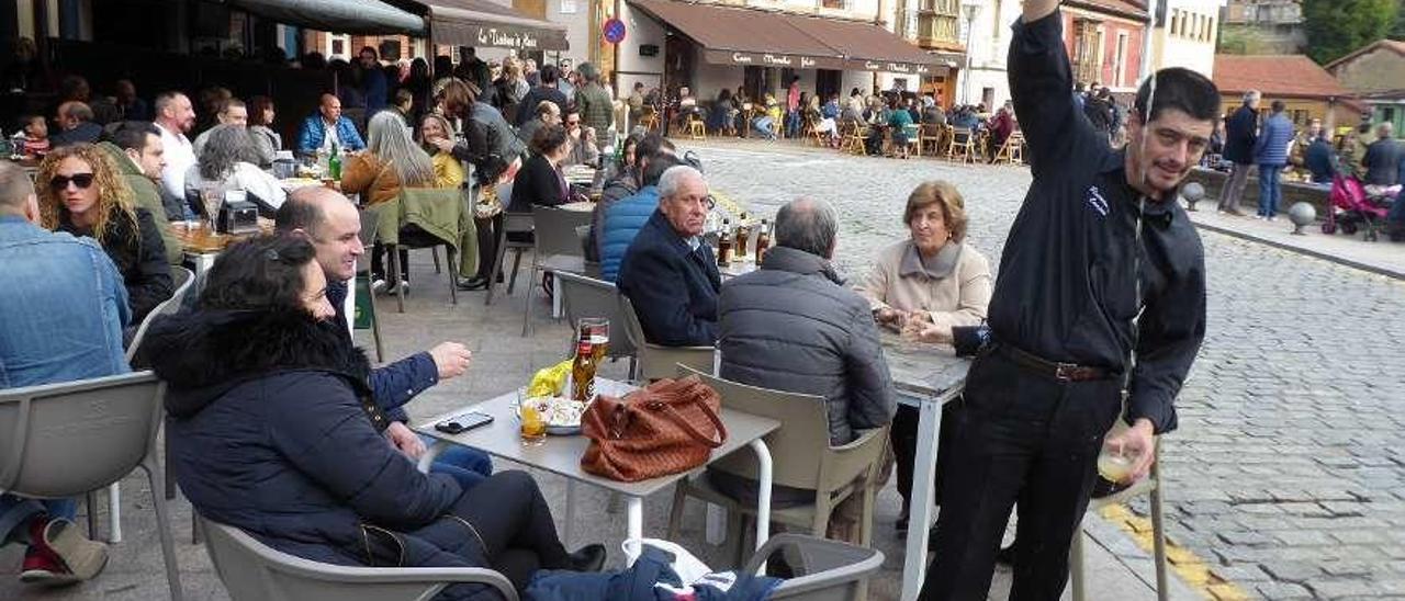 Gente en las terrazas de la plaza de Les Campes en Pola de Siero.