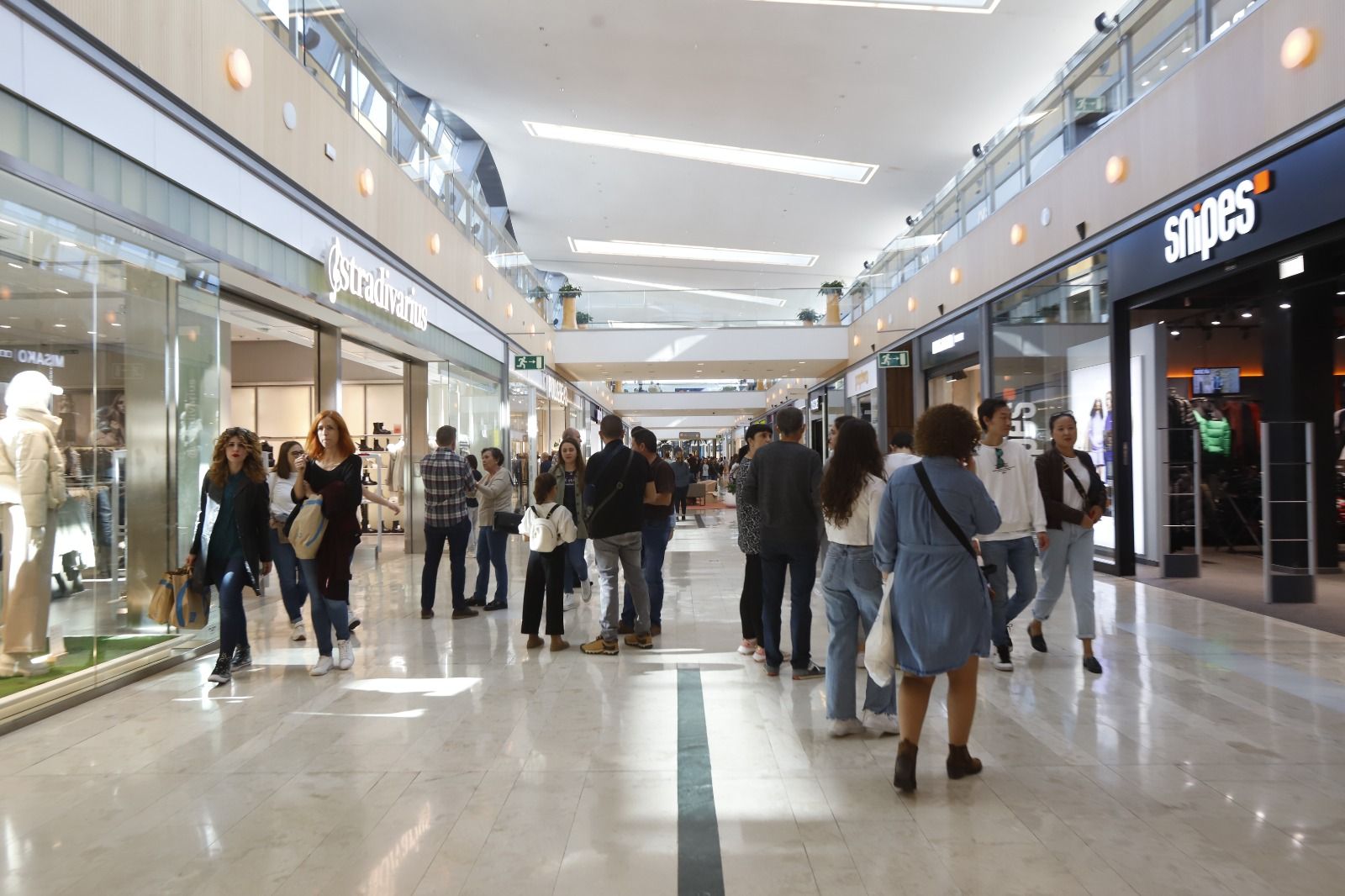 Mucha gente pero pocas bolsas en los comercios en una nueva apertura en festivo