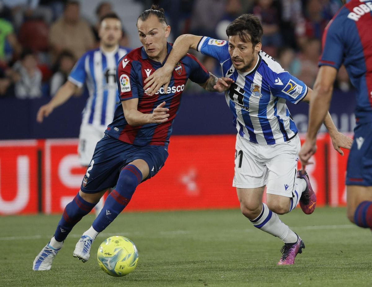 VALENCIA, 06/05/2022.- El defensa del Levante UD Francisco Javier Hidalgo Son (i) lucha con David Silva, de la Real Sociedad, durante el encuentro correspondiente a la jornada 35 de Liga en Primera División disputado hoy viernes en el estadio Ciudad de Valencia. EFE/Juan Carlos Cárdenas.