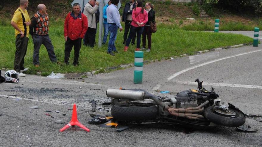 Vecinos de la zona observan la motocicleta tirada en el suelo, poco después del accidente.