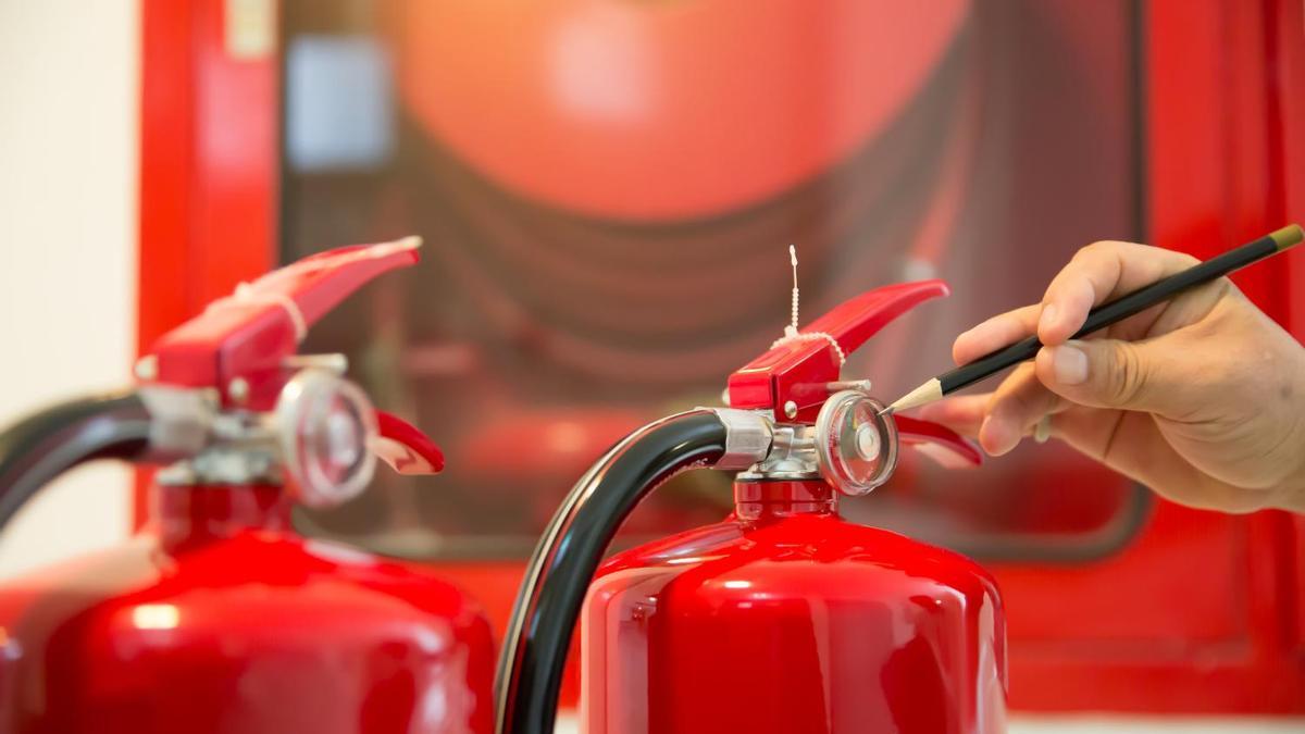 Red Fire extinguishers in the building,Engineers are checking fire extinguishers.