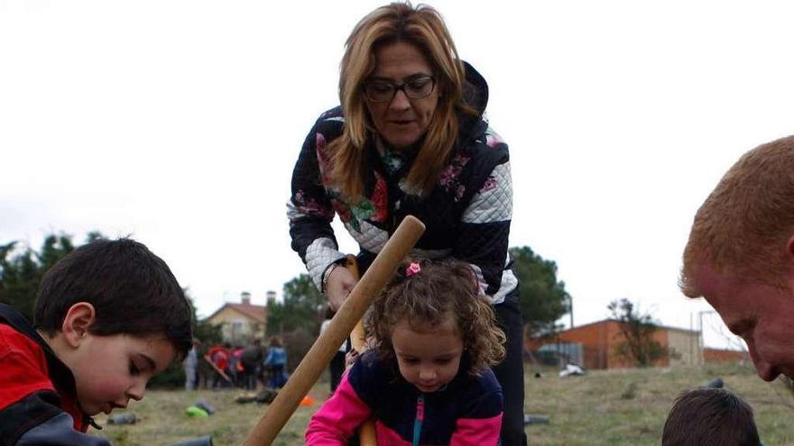 Martín Pozo ayuda a una niña con la pala para que el arbolito quede bien sujeto.