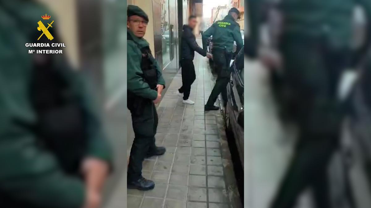 Los agentes custodian a uno de los arrestados.