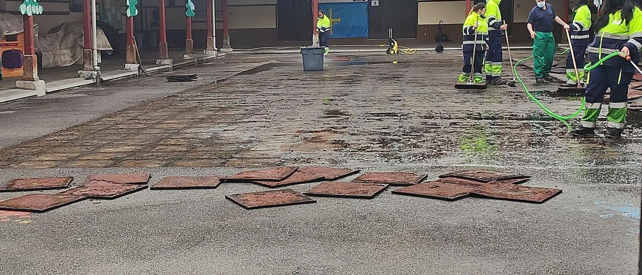 Trabajadores efectúan arreglos en el suelo de caucho del colegio Santiago Apóstol de Mieres. | A. Velasco