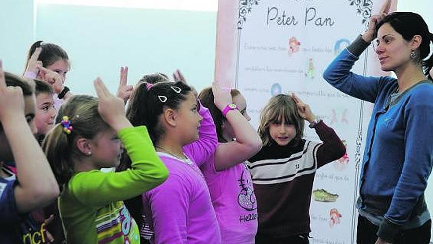 Lucía Lorite enseña el signo de Wendy, uno de los personajes de las aventuras de Peter Pan, a los niños de La Corredoria.