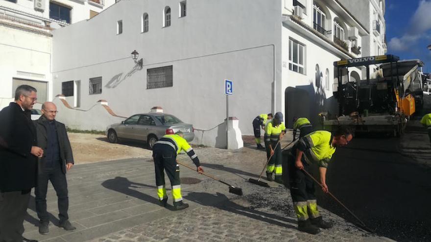 Varios operarios asfaltan una calle en Mijas.