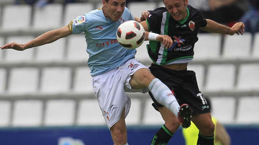 Roberto Lago salta por un balón con un jugador del Elche. // Ricardo Grobas