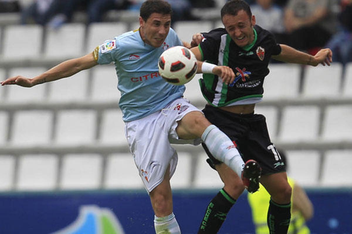Roberto Lago salta por un balón con un jugador del Elche. // Ricardo Grobas