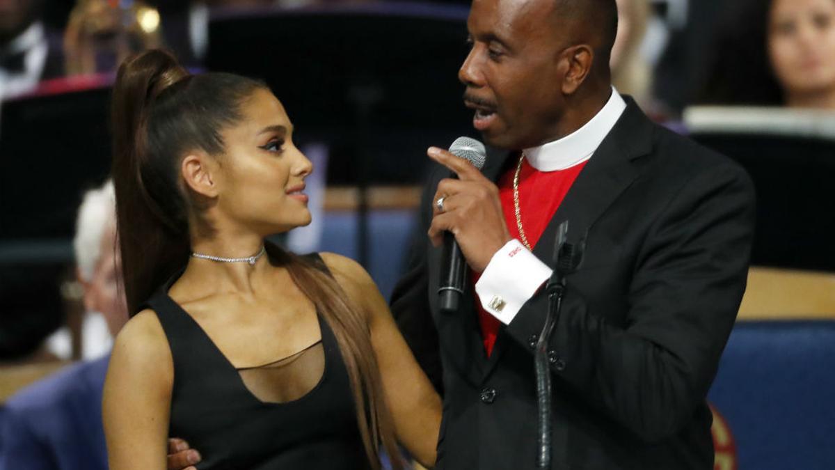 El reverendo Charles Ellis sujeta a Ariana Grande durante el funeral de Aretha Franklin