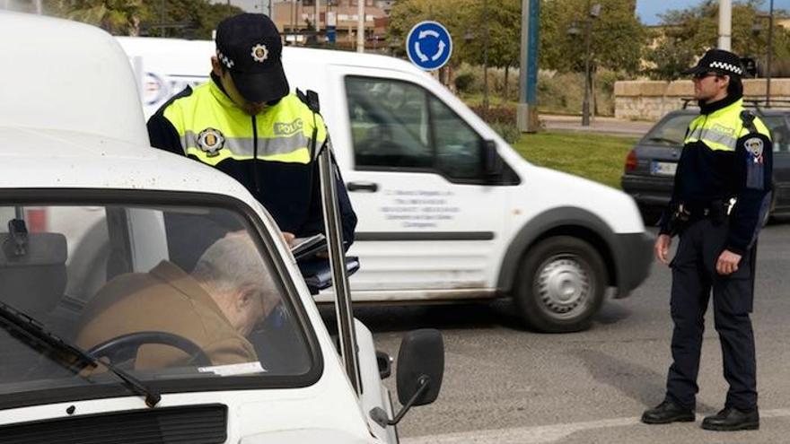 Un agente de la Policía Local imponiendo una multa al conductor de un vehículo.