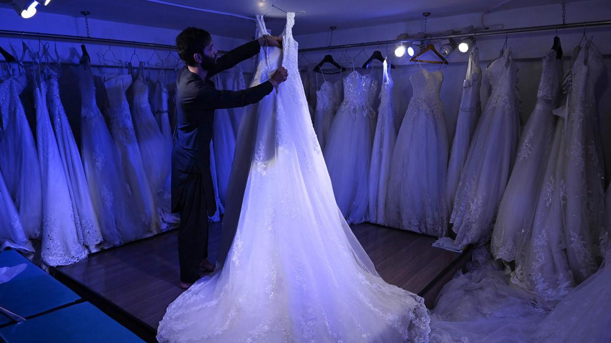 Un dependiente arregla un vestido de novias en una tienda de Kabul, este jueves.