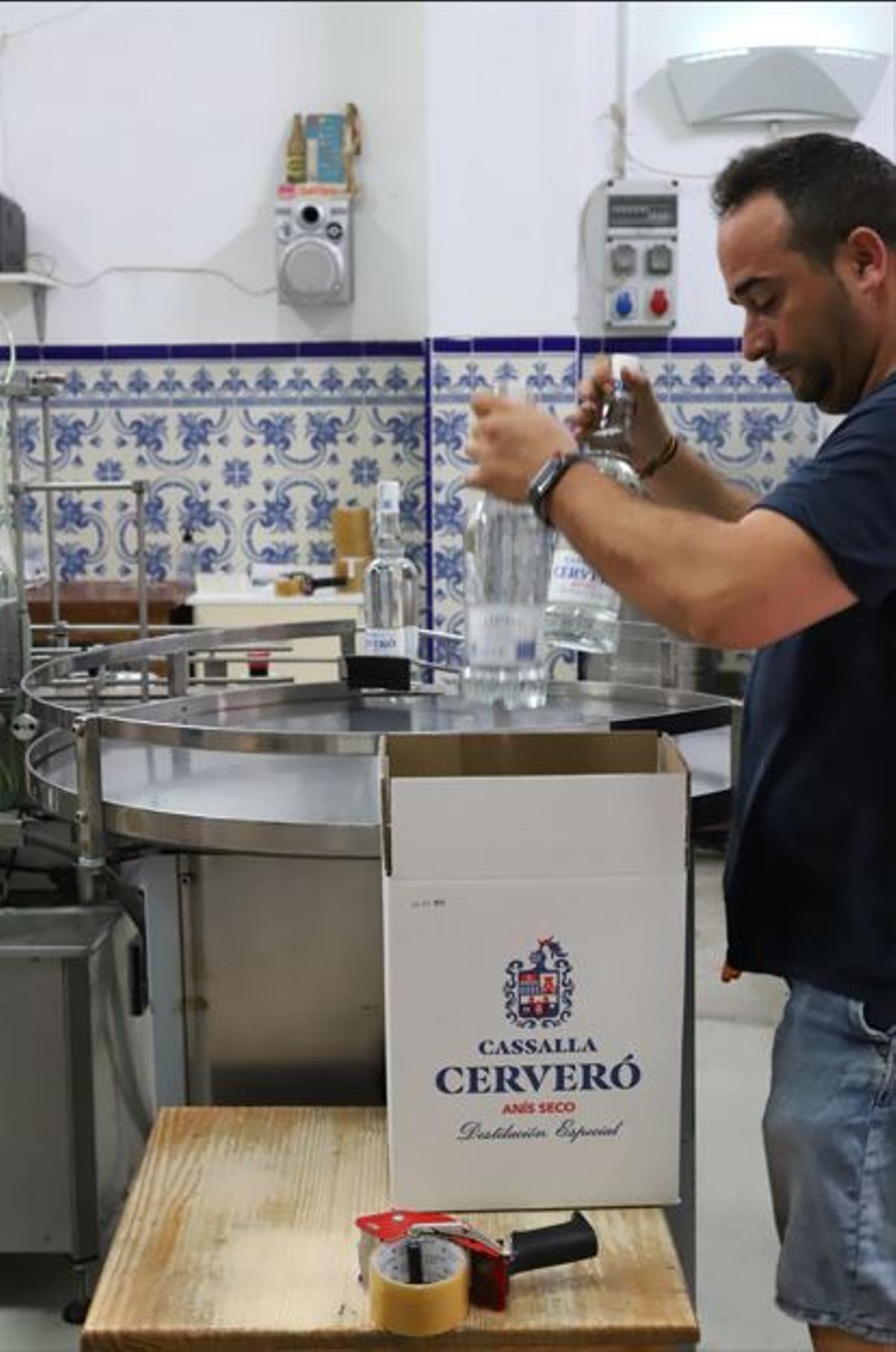 Un operario introduce las botellas en la caja para su comercialización.