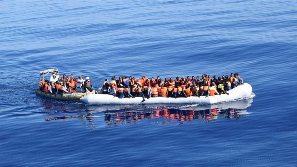 Foto de la marina italiana que muestra una embarcación con inmigrates y refugiados a la deriva en el Meditarráneo.