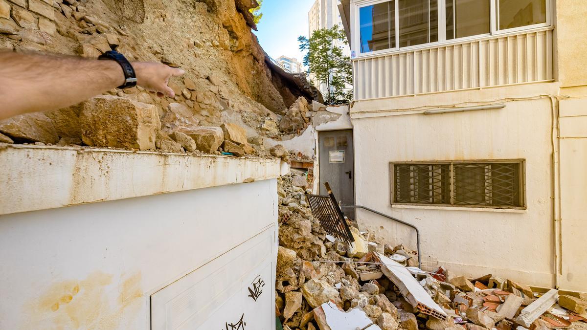 Uno de los vecinos señala la zona del derrumbe del talud en Benidorm.