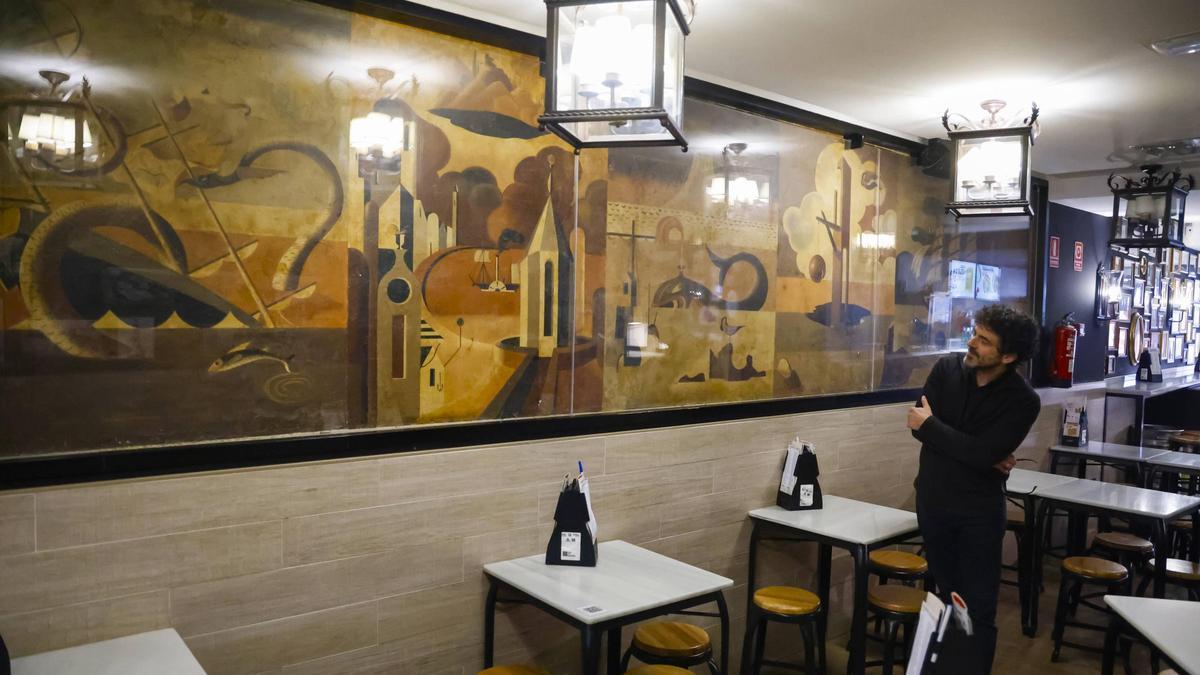 Henrique Alvarellos observa o mural de Urbano Lugrís pintado nun local da rúa do Franco