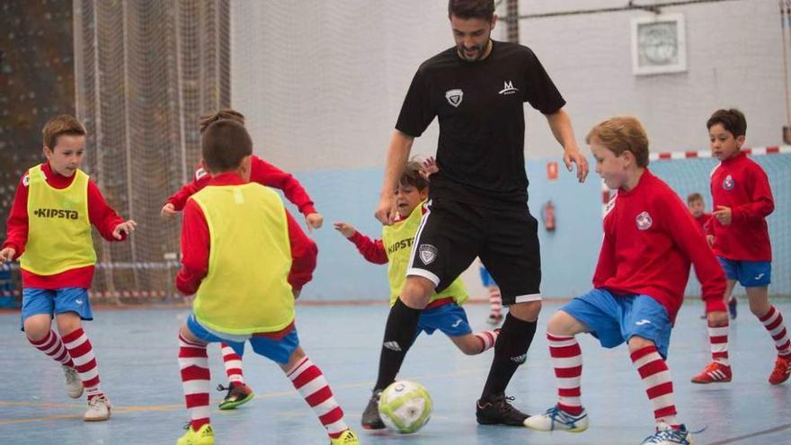 David Villa juega con un grupo de niños durante la reciente presentación de su campus en Llanera.