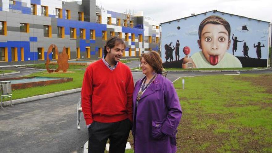 Manuel Suárez y María Teresa Rodríguez, ante el grafitti de El Séptimo Crío, con la residencia a la izquierda.