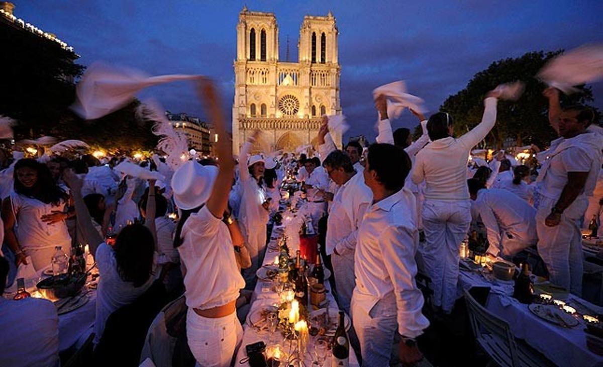 Un grup de persones sopen aquest dijous davant la parisenca catedral de Notre Dame la nit del ’dîner en blanc’ (sopar de blanc), en què els que vulguin participar han de vestir-se de blanc i portar el seu propi menjar al lloc emblemàtic de la capital francesa que hagi estat elegit en l’edició de l’any.