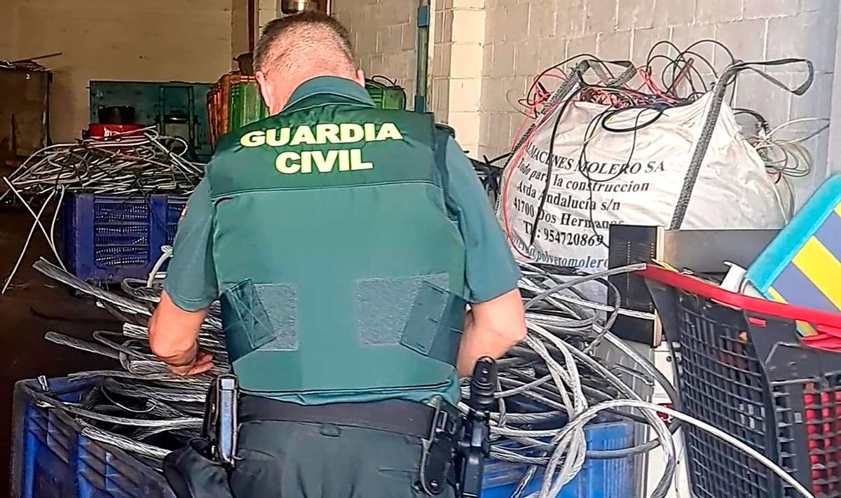 Un agente de la Guardia Civil con los efectos robados.