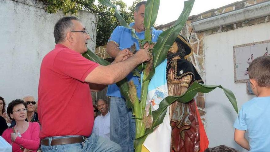 Los vecinos colocan el maíz en la imagen del Apóstol.