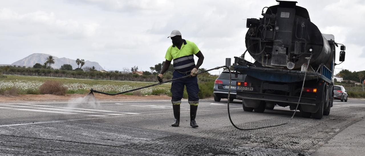 Un operario asfaltando un tramo del Camino Viejo de Alicante este mismo jueves
