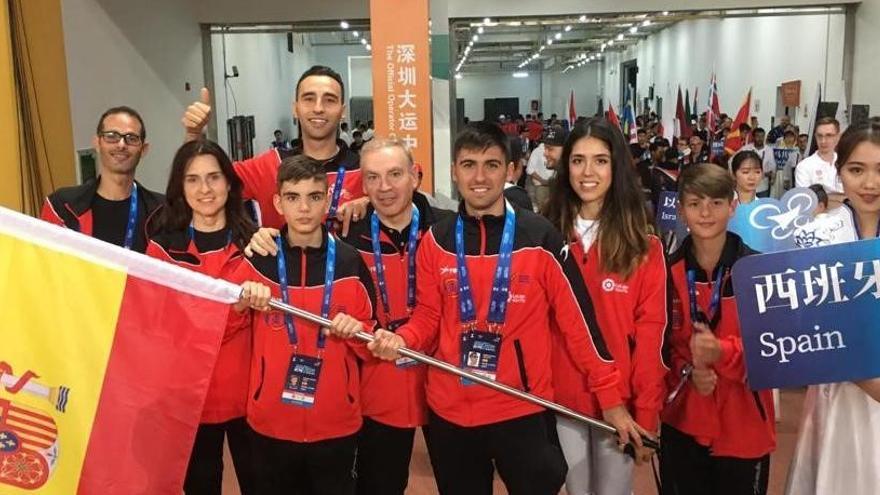 Padre e hijo sostienen la bandera junto al equipo que viajó a China el pasado año.