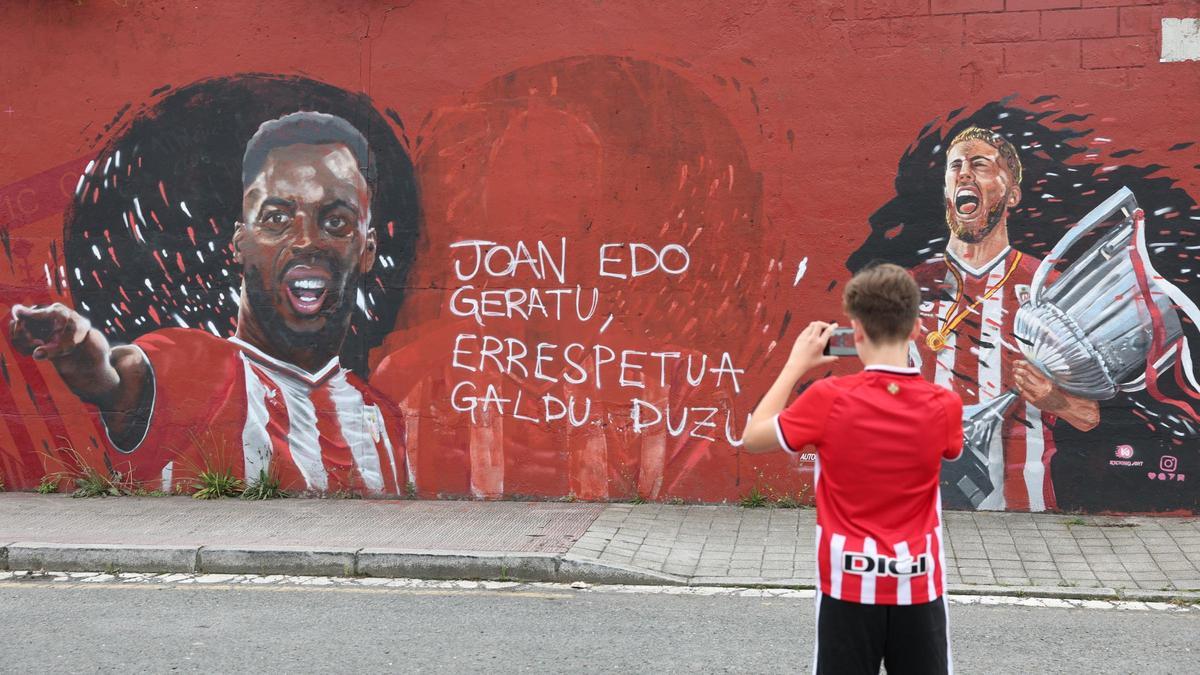 Un aficionado del Athletic realiza una foto del mural en Barakaldo donde se suprimió la imagen de Nico Williams entre Iñaki y Muniain. Un aficionado del Athletic realiza una foto del mural en Barakaldo donde se suprimió la imagen de Nico Williams entre Iñaki y Muniain.