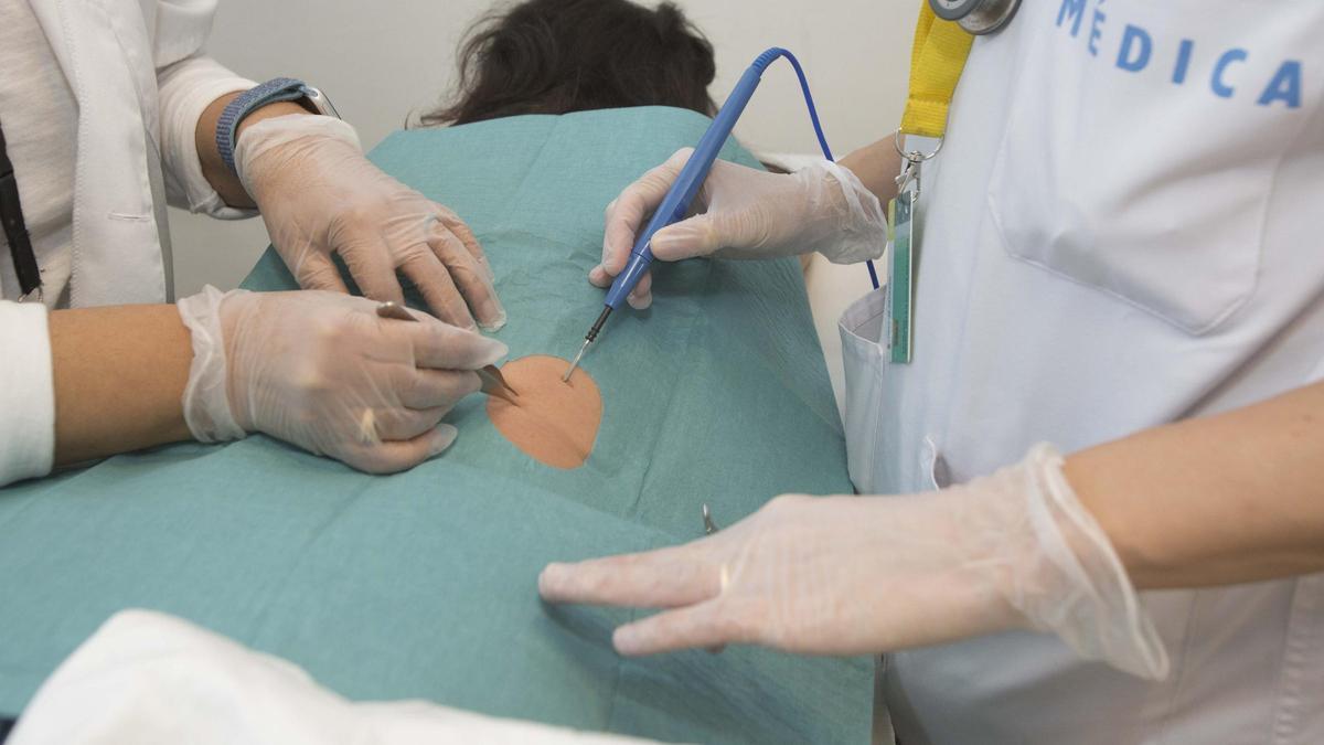 Una facultativa atendiendo a una paciente en un proceso de cirugía menor.