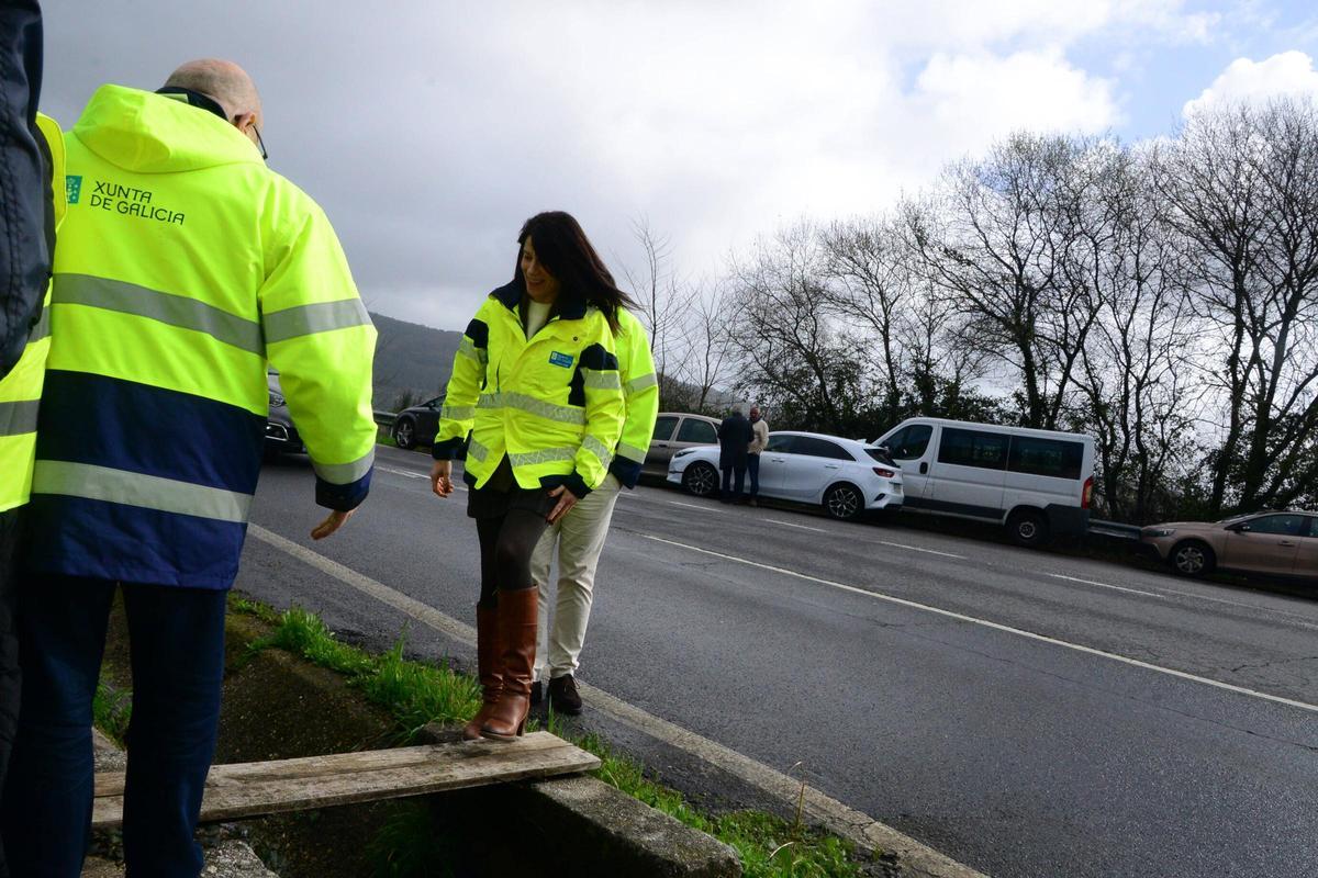 Allegue llega a la carpa pasando por las tablas de madera sobre el agua que baja por la cuneta de la PO-313.
