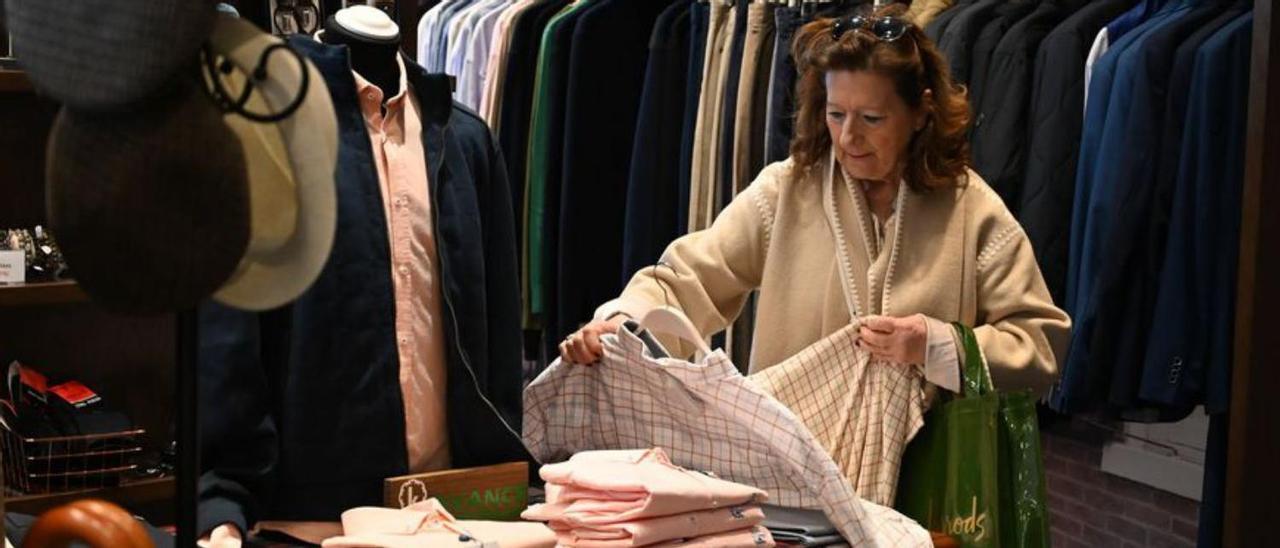 Una mujer busca entre las camisas el regalo ideal.