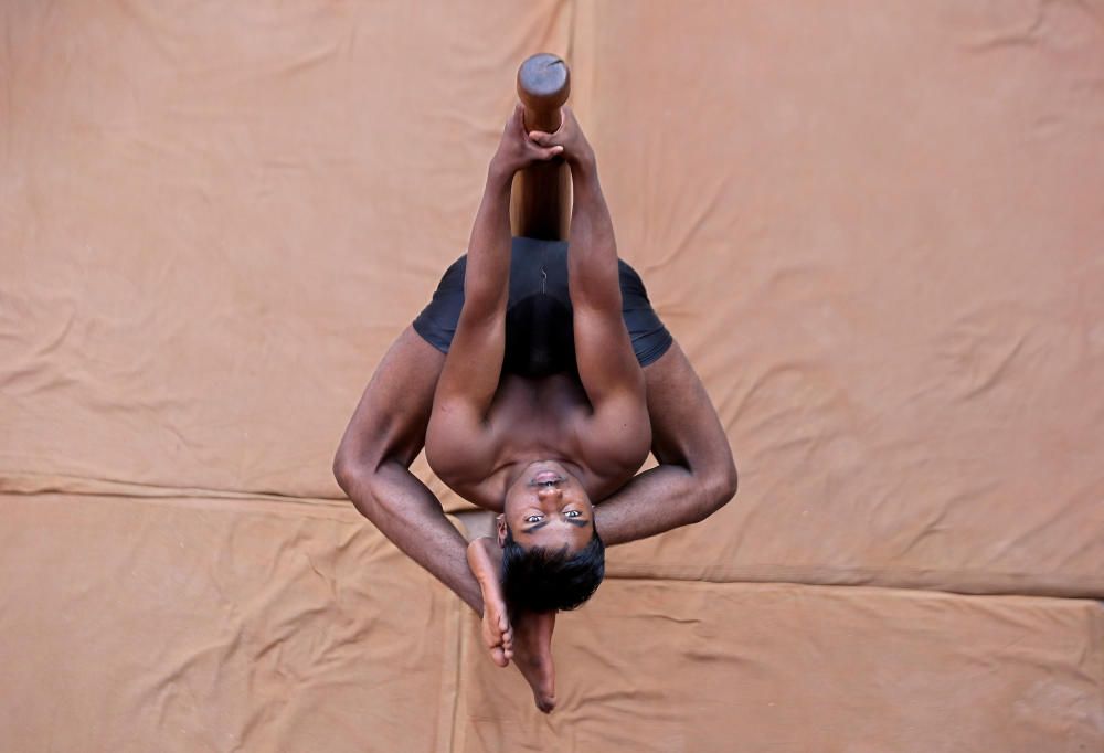 A participant practices "Mallakhamb" during a ...