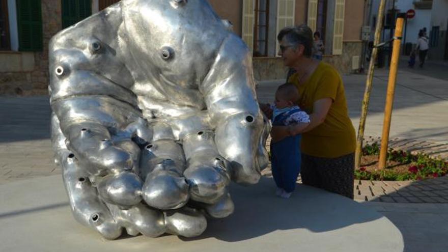 Una abuela enseña a su pequeña nieta la escultura ‘Help’. | BIEL CAPÓ