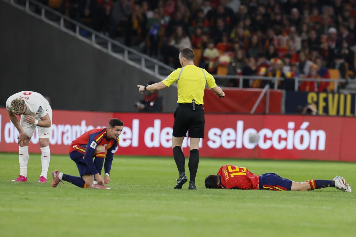 SEVILLA, 18/11/2025.- El defensa de la selección española, Pau Cubarsí (d), se duele en el terreno de juego tras un choque con el centrocampista de Turquía, Baris Alper Yilmaz (i), durante el encuentro correspondiente a la fase de clasificación para el Mundial 2026 que disputan hoy martes España y Turquía en el estadio de La Cartuja, en Sevilla. EFE / José Manuel Vidal.