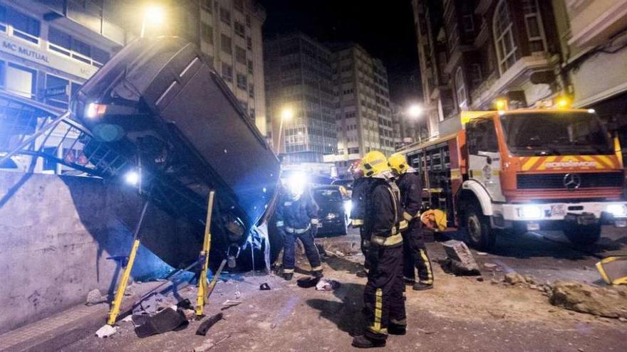 El coche accidentado, colgado de la barandilla y volcado en la bifurcación de Juan Flórez.