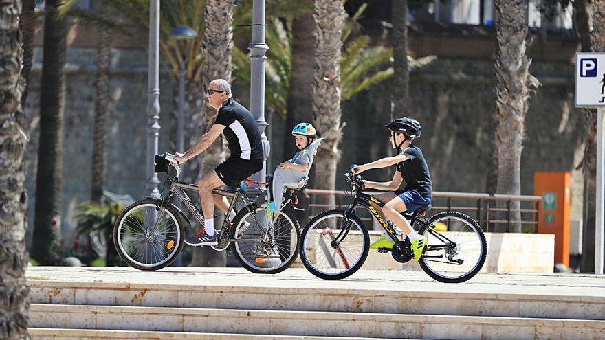 Una familia de ciclistas recorre el muelle Alfonso XII.