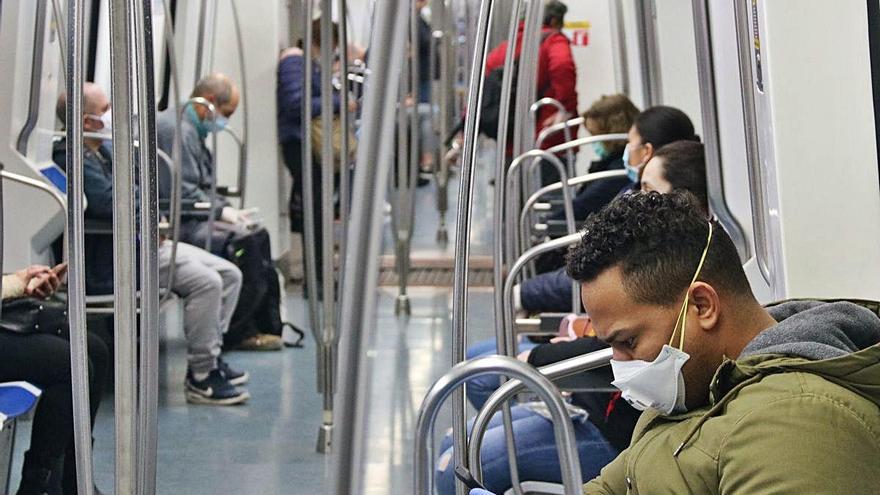 Passatgers amb mascaretes en un vagó del metro de Barcelona