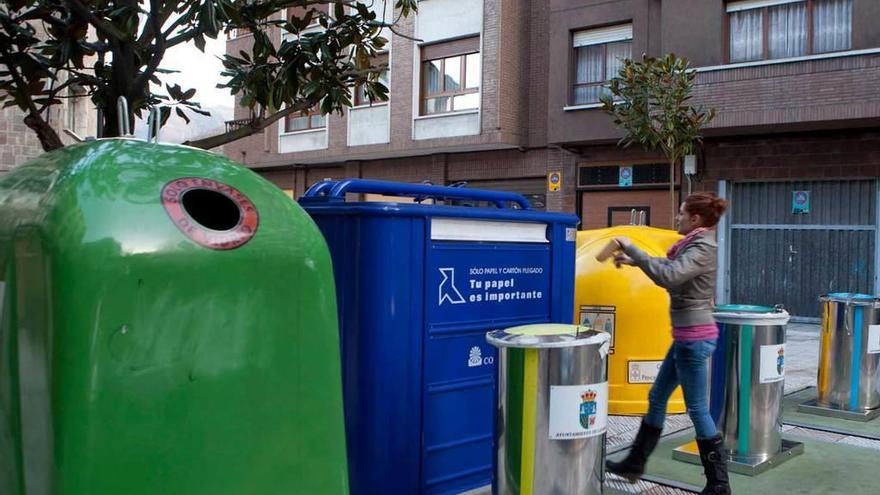 Una joven recicla en la calle Poeta Alfonso Camín de Sama, que dispone de seis contenedores de reciclaje para papel, envases y vidrio.