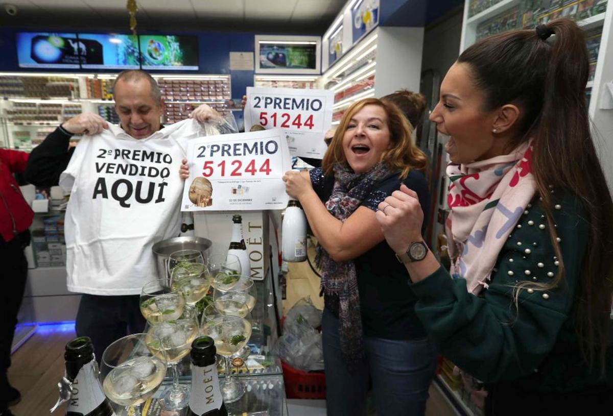 Los propietarios de la administración de lotería de la calle Ripoche en Las Palmas de Gran Canaria celebran el segundo premio vendido en su oficina y que ha recaído en el número 51244. EFE