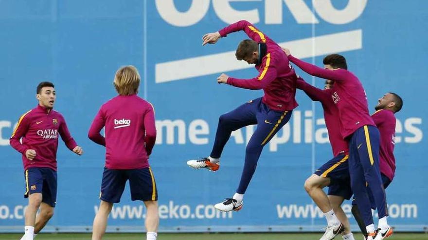 Piqué y Bartra disputan un balón de cabeza, ayer, en el entrenamiento del Barça.