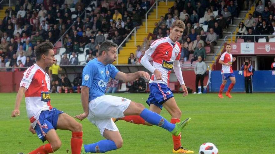 Rubén Rivera trata de rematar un balón entre los arlequinados Julio Rey y Pablo González, en un lance del partido de ayer. // Noé Parga