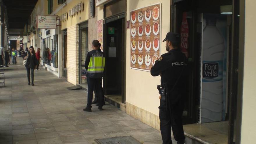 Dos policías, en el local de la plaza Major clausurado en diciembre donde ayer se retiró comida podrida.