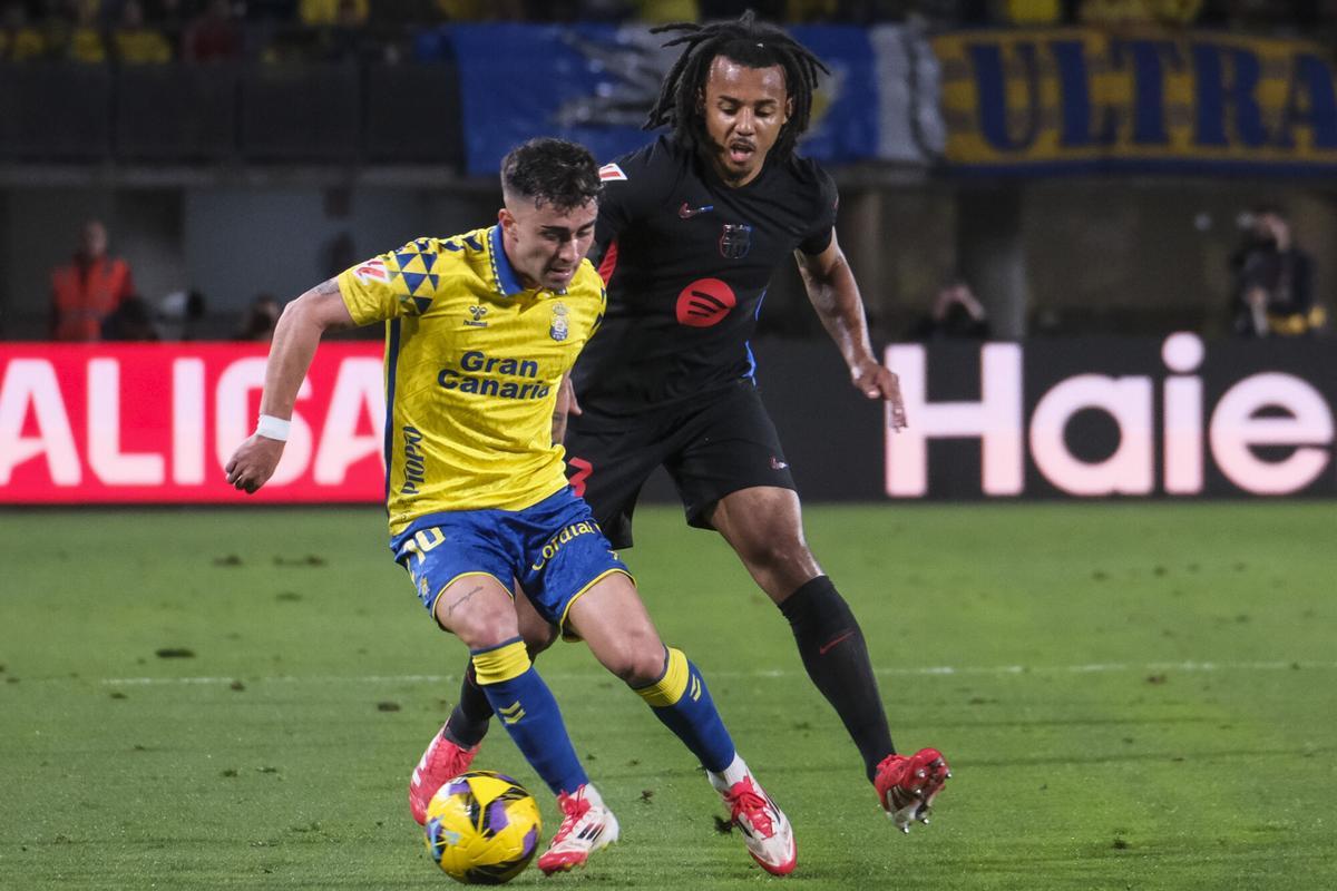 Las Palmas de Gran Canaria, 22/02/2025.- El centrocampista de la UD Las Palmas, Alberto Moleiro (i), controla el balón ante el defensa francés del FC Barcelona, Jules Koundé, durante el encuentro correspondiente a la jornada 25 de Laliga EA Sports que disputan hoy sábado en el estadio de Gran Canaria. EFE / Angel Medina. G.