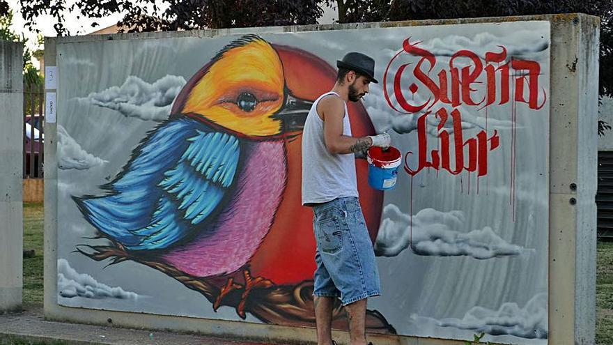 Un joven pinta un mural en Benavente, en una foto de archivo