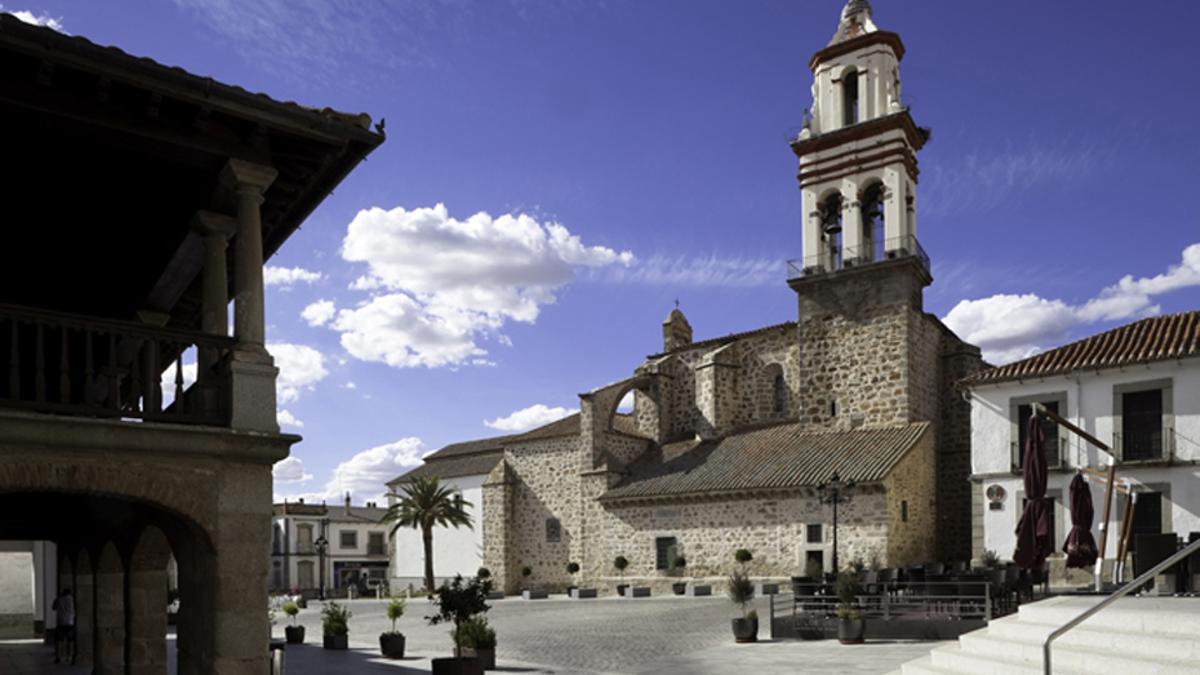 Plaza Mayor de la localidad, con la iglesia de la Asunción al frente y unos característicos soportales a la izquieda.