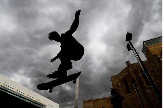 Un niño en monopatín en la Plaza dels Angels frente al museo MACBA en Barcelona.