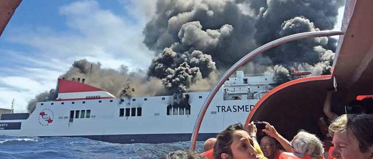 Pasajeros evacuados en alta mar, junto al ferry incendiado.