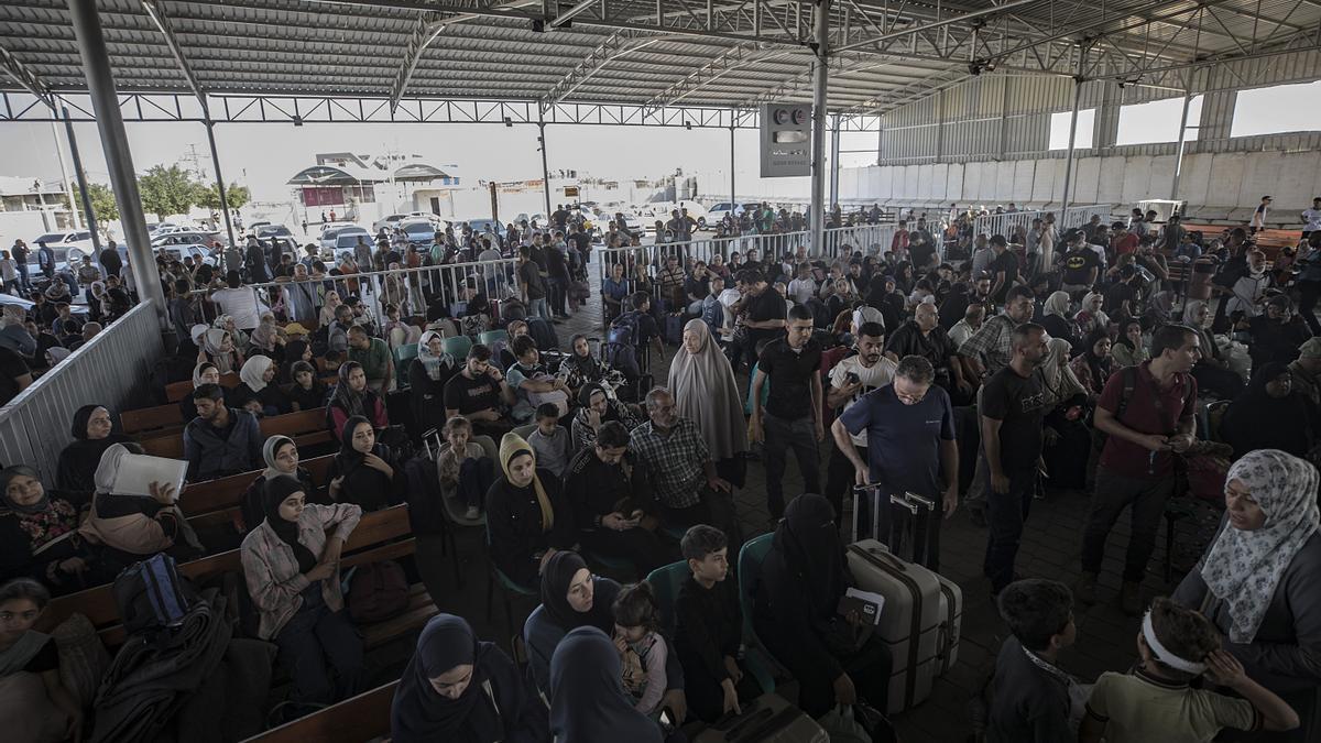 Decenas de personas esperan en el lado palestino del paso de Rafah.